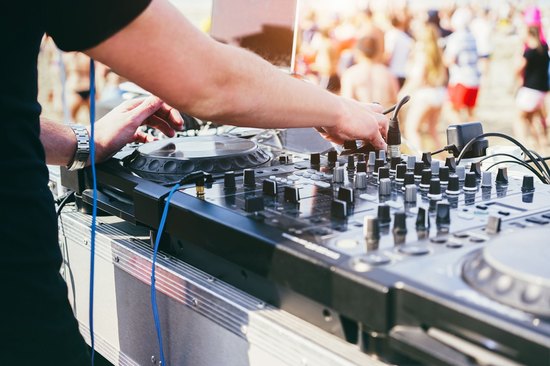 Dj mixing at beach party during summer vacation outdoor - Focus on right hand