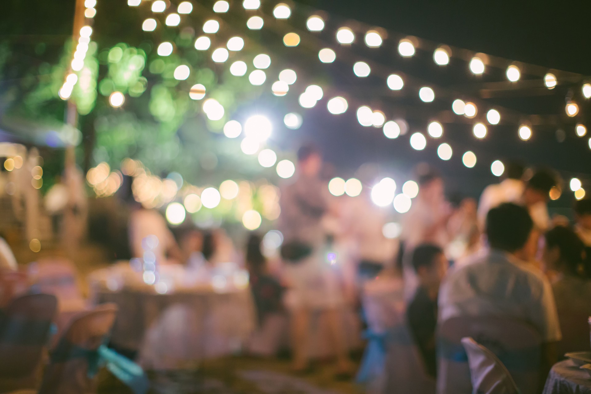 vintage tone blur image of food stall at night festival with bokeh for background usage. Festival Event Party with People Blurred Background. Blur people having sunset beach party in summer vacation